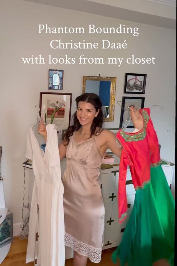 Andrea holding up Christine looks from her closet