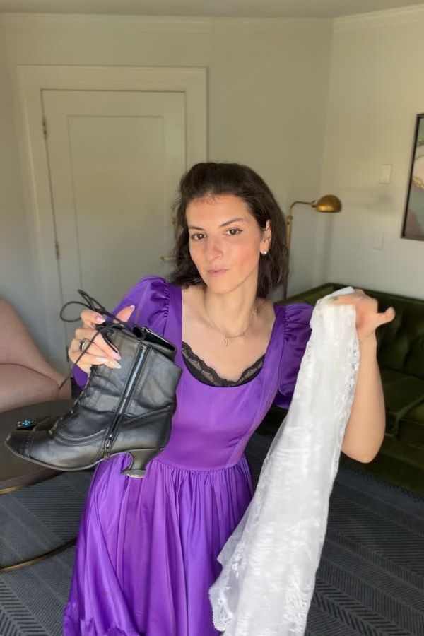 Andrea in a purple Chelsea Reece dress holding boots and a white robe